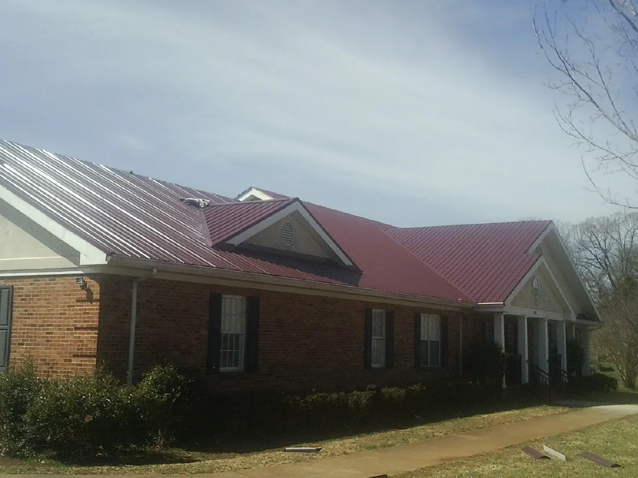 Red metal roof with gabled entries on a long brick building in Indian Trail