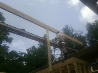 Carpenter setting a ridge beam over a new addition frame — Ice Dam Removal by Roofing Brothers in Indian Trail