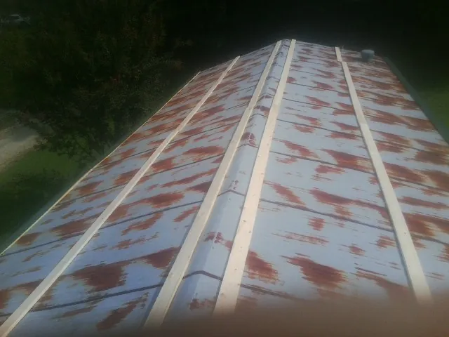 Rusted metal roof panels with new wood purlins before replacement — Storm Damage Roof Repair in Indian Trail by Roofing Brothers