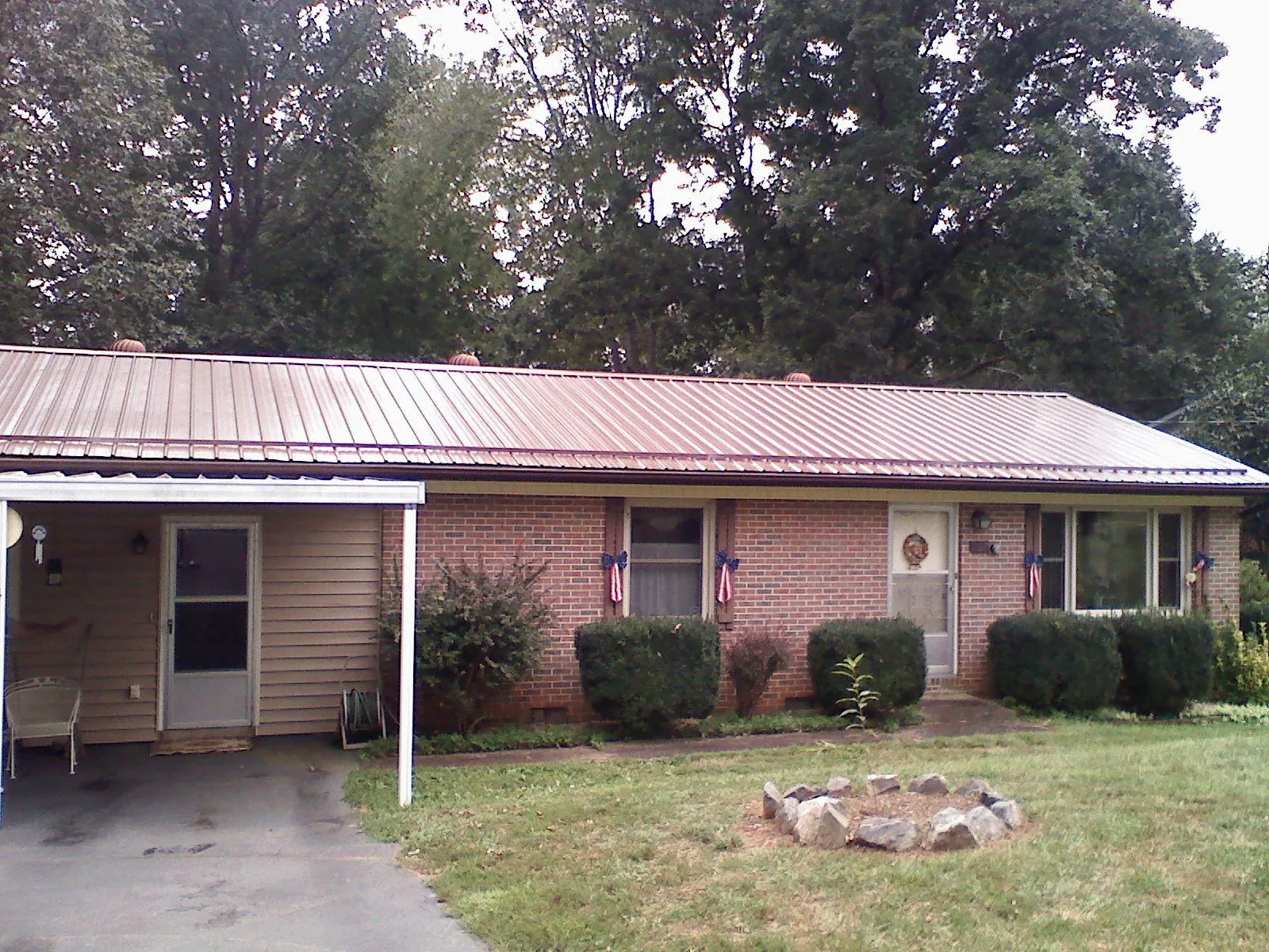 Bronze metal roof and carport on a brick ranch home — Roof Repair work by our crew in Indian Trail