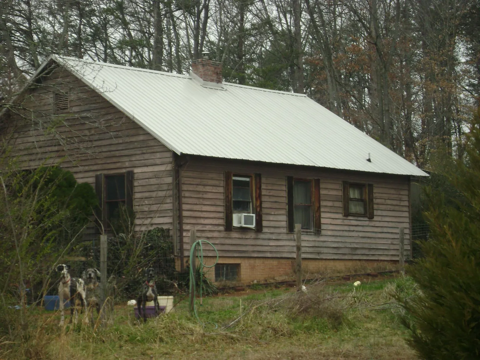 White metal roof on an old wood sided farmhouse, from a Metal Roof Installation job in Indian Trail